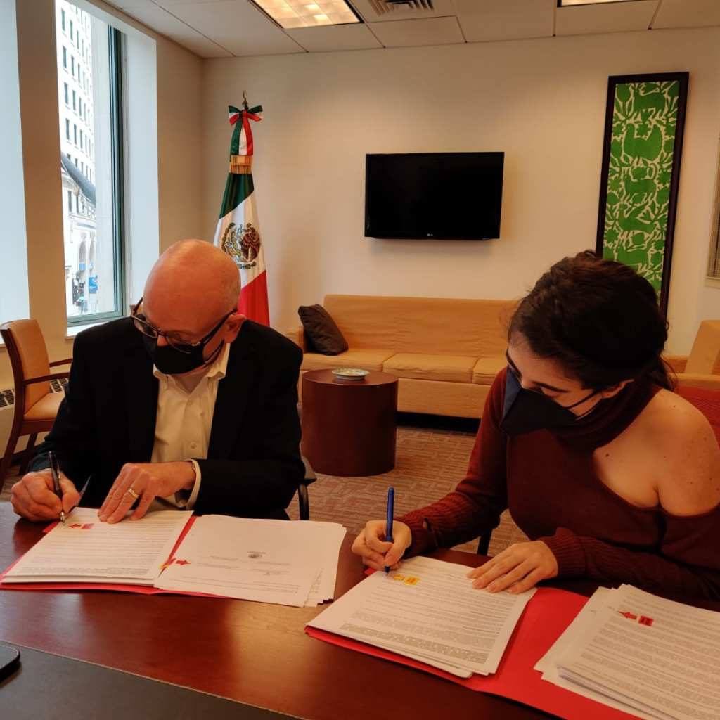 man and woman sitting at a desk signing documents