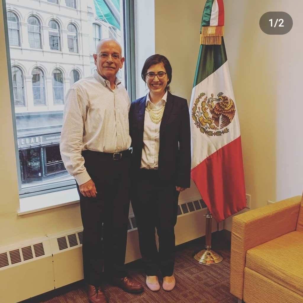 man and woman standing in front of a mexican flag