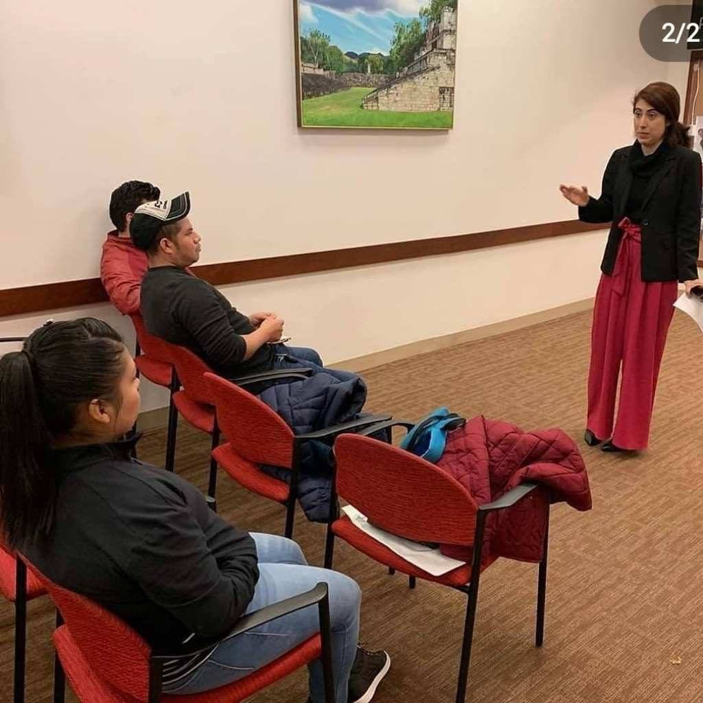 woman standing in a room addressing a group